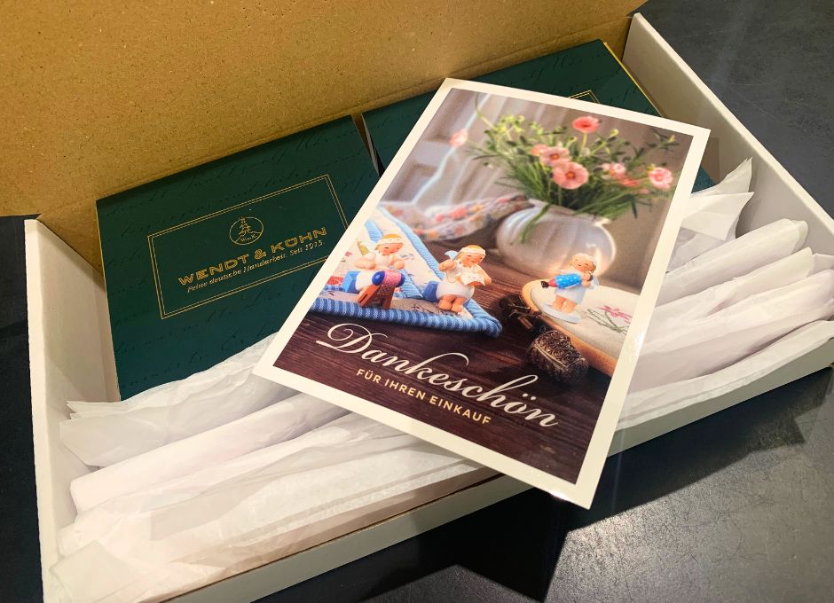 Blick in Paket mit Figuren von Wendt & Kühn und Dankespostkarte für Online-Kauf auf Online Marktplatz