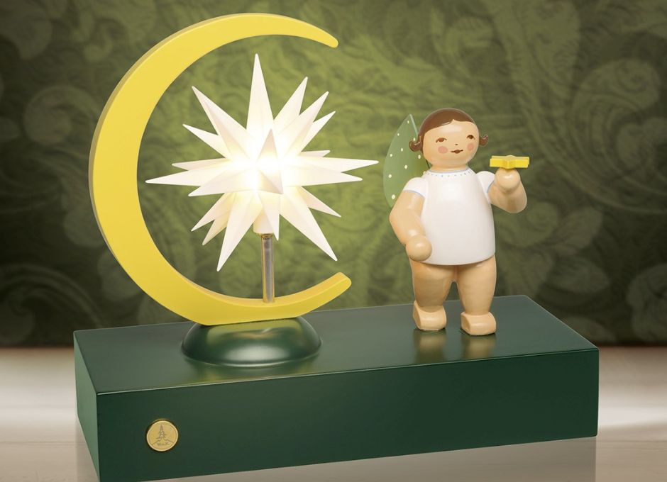 Engel mit Miniatur- Stern in der Hand auf Sockel mit beleuchtetem großem Stern